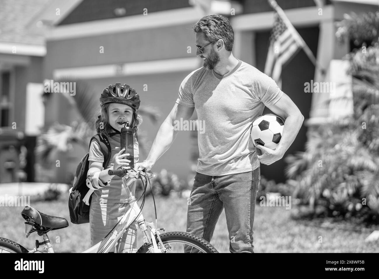 father and son kid developing his childhood on bicycle outdoor together