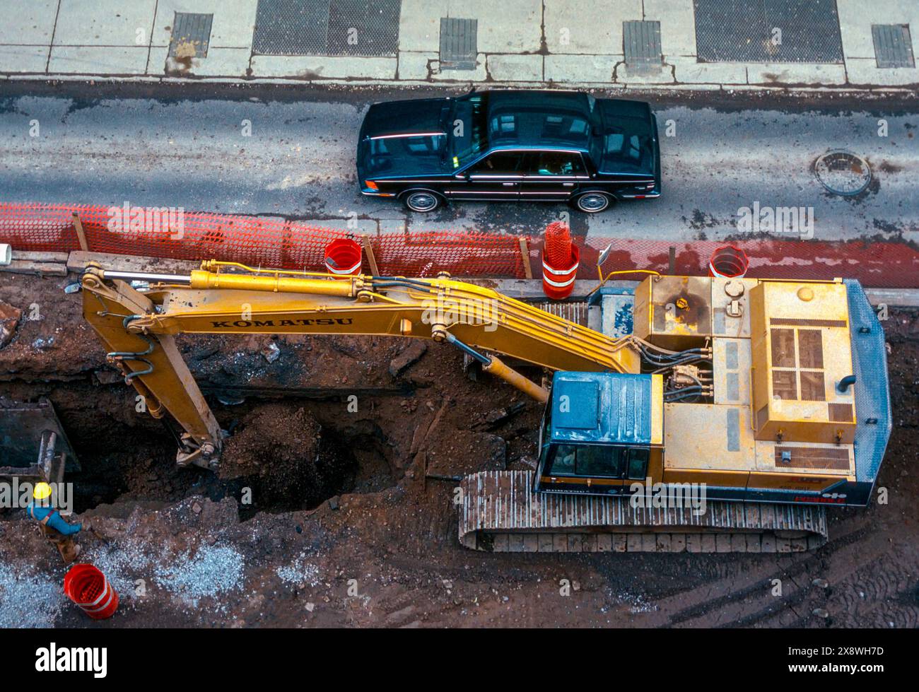 Street Construction.  Kumatsu Excavator Digging a Hole in Street. North Clinton Avenue. Rochester, New York Stock Photo