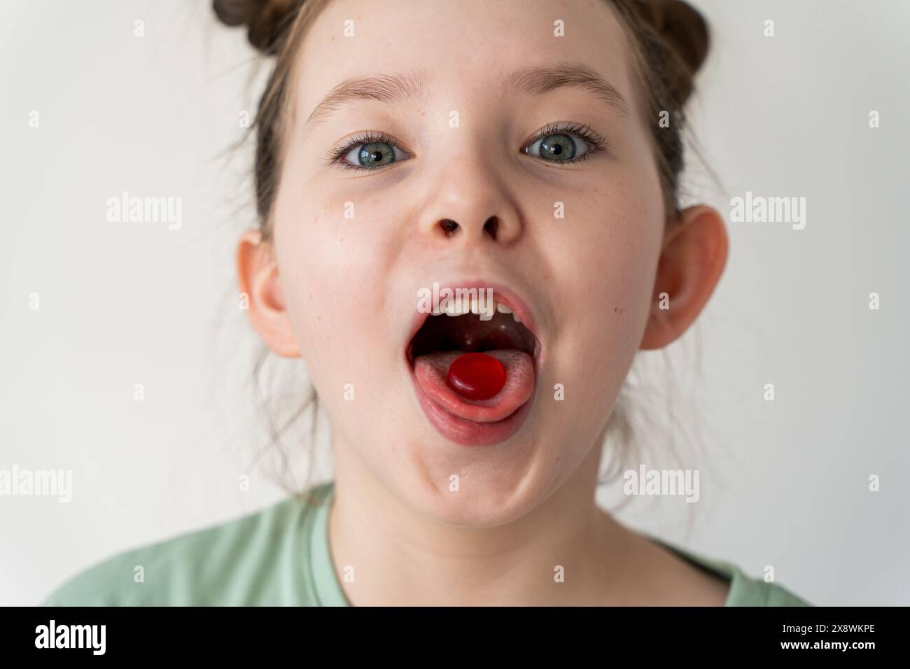 mouth girl little Cheerful little girl holding a pill in her mouth, a red lollipop. Easy  treatment of the throat. High quality photo Stock Photo - Alamy