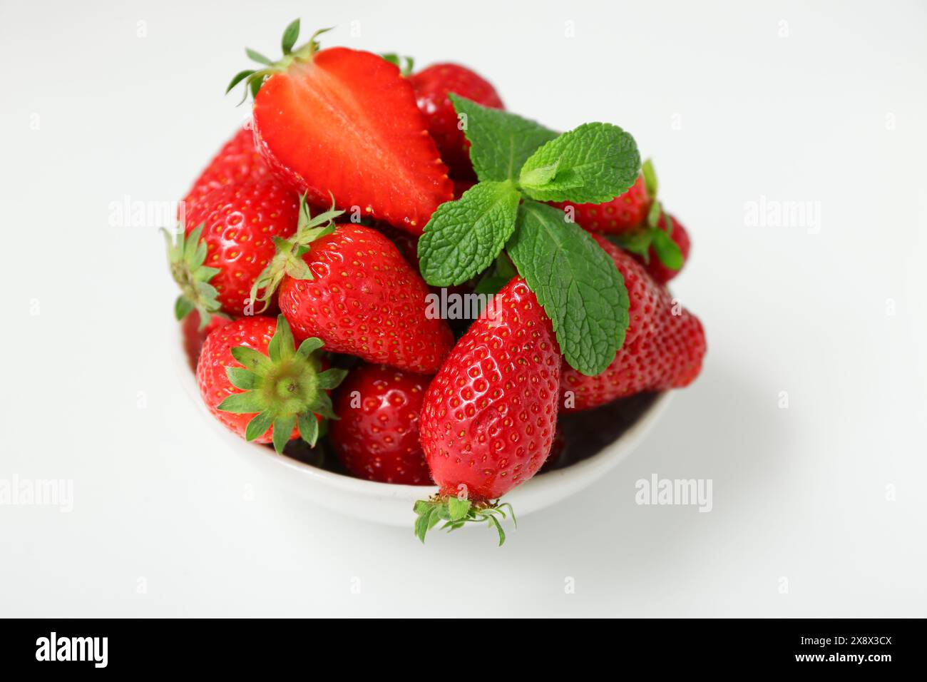 Bowl with sweet fresh strawberries and mint on white background Stock ...
