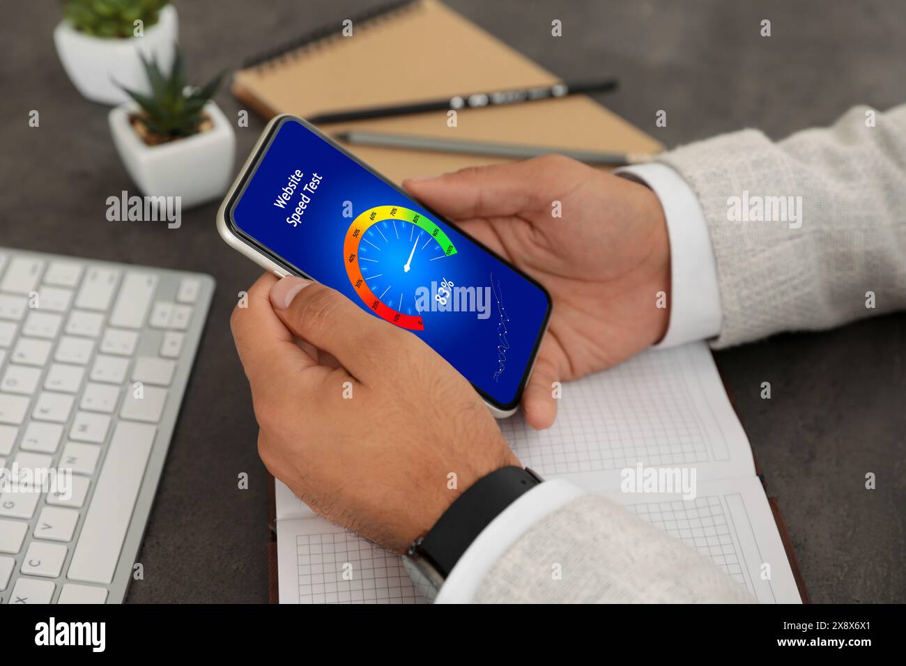 Website speed test. Man using mobile phone at table, closeup Stock Photo