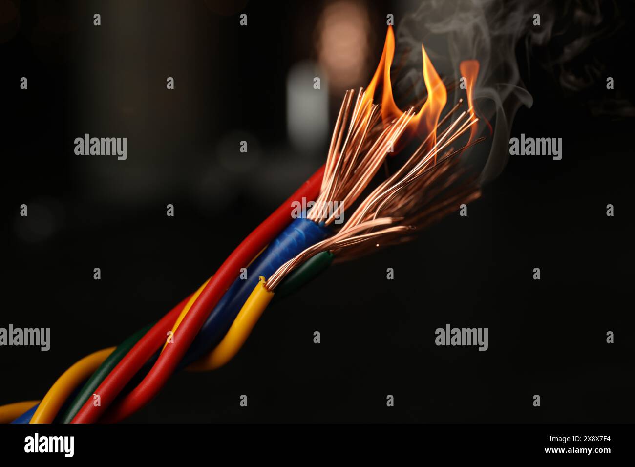 Electrical wire burning on dark background, closeup Stock Photo