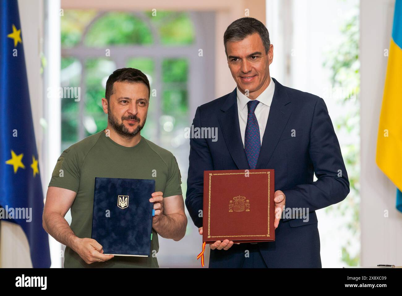 Madrid, Spain. 27th May, 2024. President of Ukraine Volodymyr Zelenskyy (L) and Spanish Prime Minister Pedro Sanchez (R) exchange books as they sign an agreement at Moncloa Palace. Spain and Ukraine sign a bilateral security agreement: 'Defense, security, peace, and reconstruction are our priorities.' Credit: SOPA Images Limited/Alamy Live News Stock Photo
