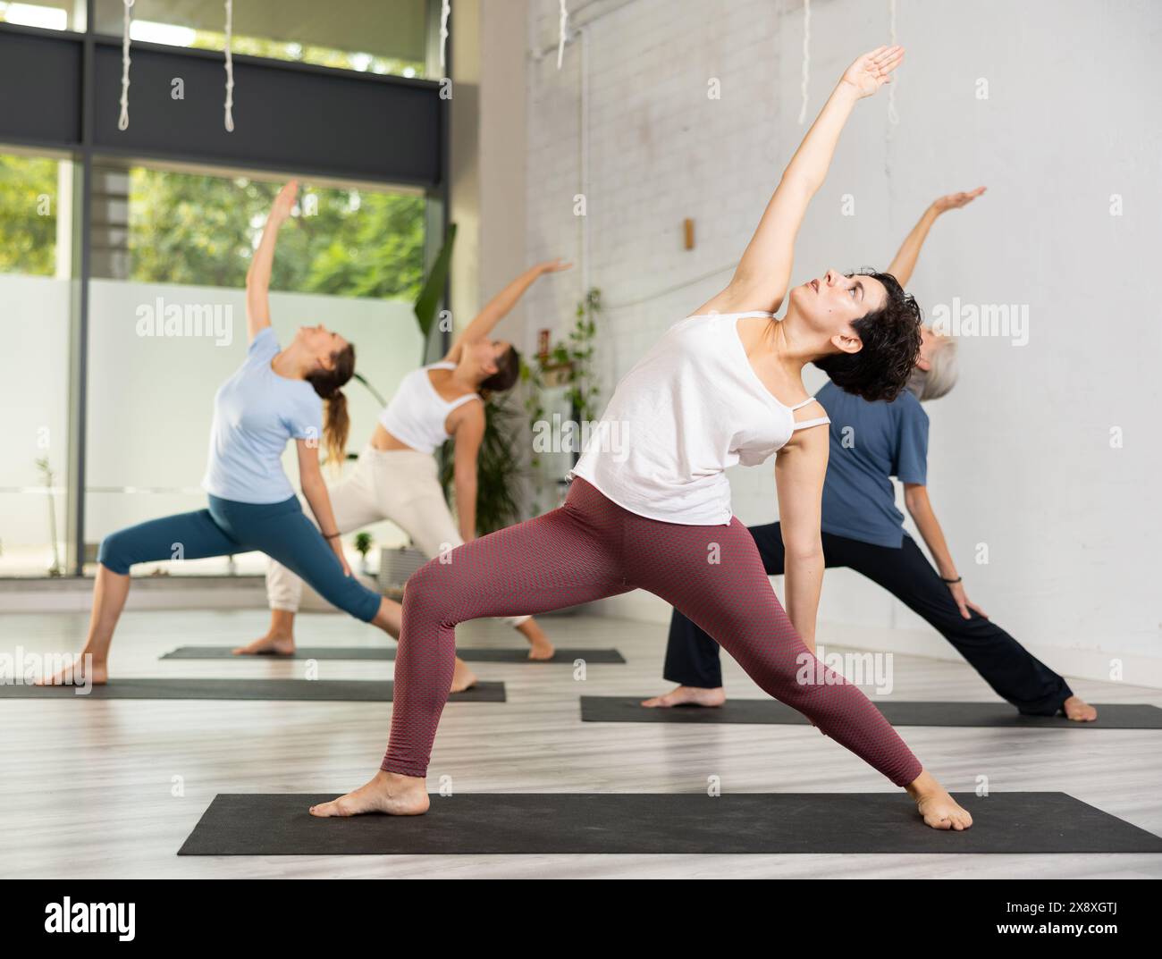 Concentrated Young Woman Performing Revolved Side Angle Pose Parivrtta concentrated-young-woman-performing-revolved-side-angle-pose-parivrtta