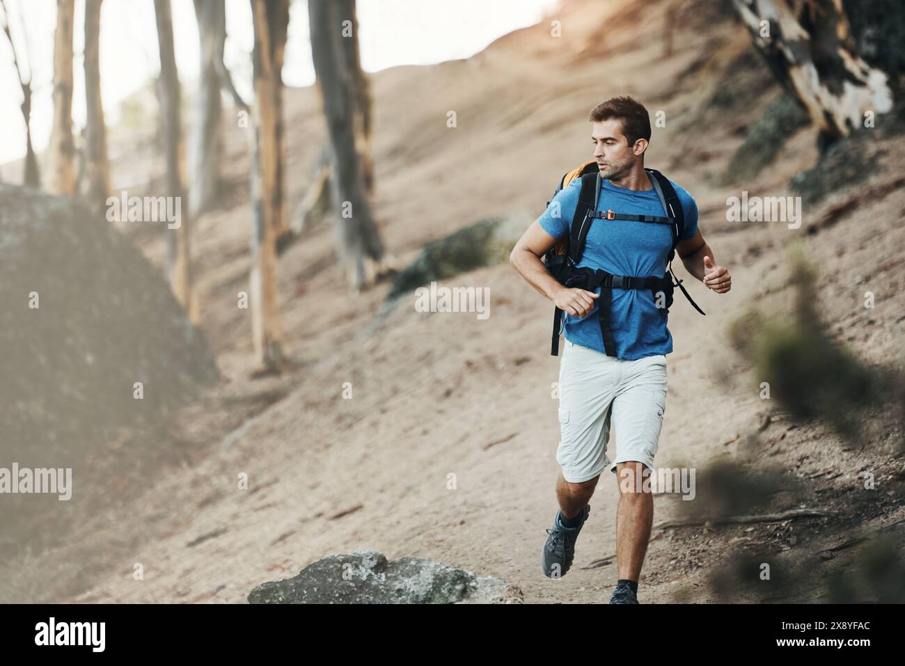 Man, backpack and running in nature forest for wilderness experience ...