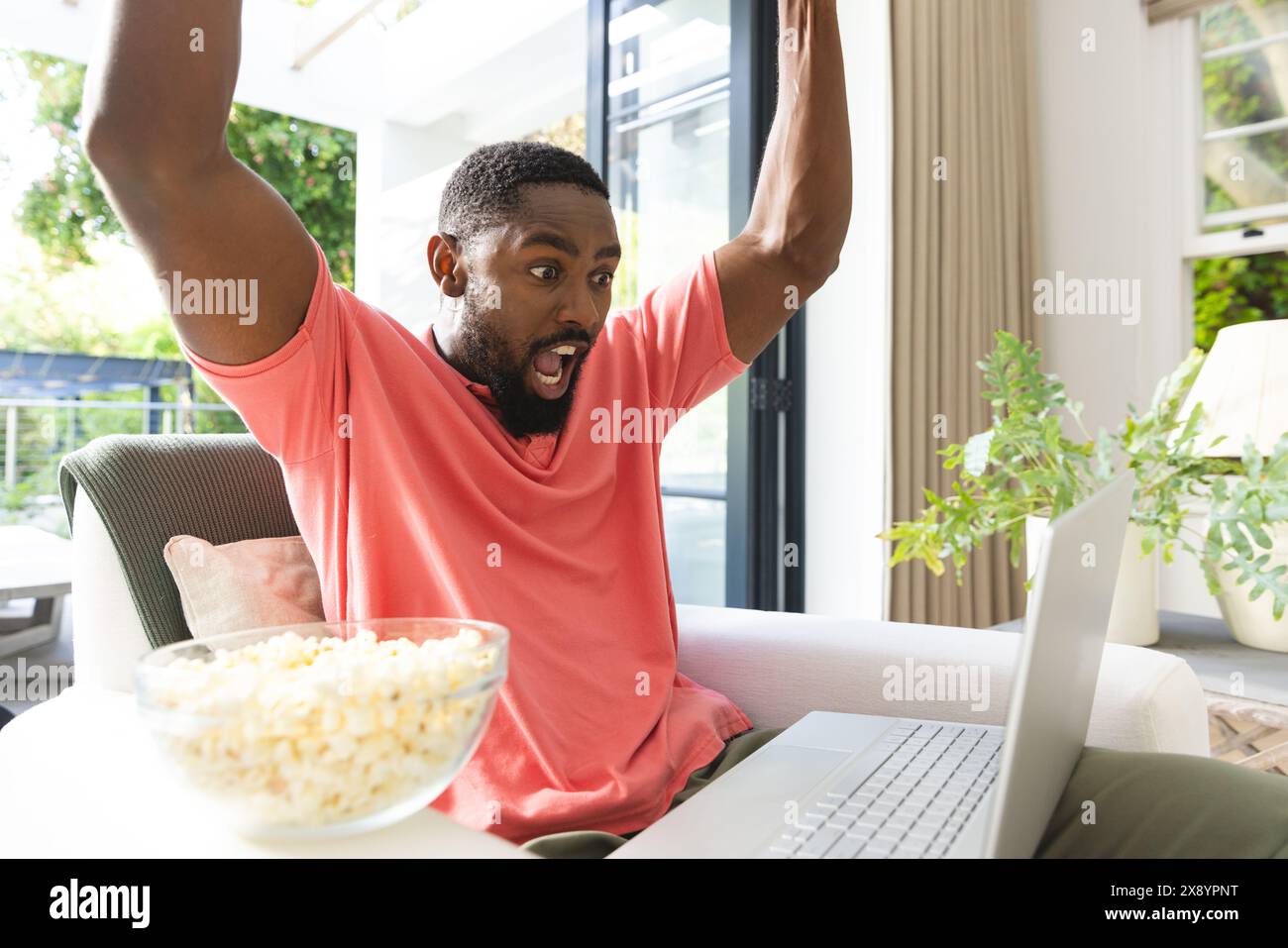 African American man celebrating in front of laptop at home Stock Photo