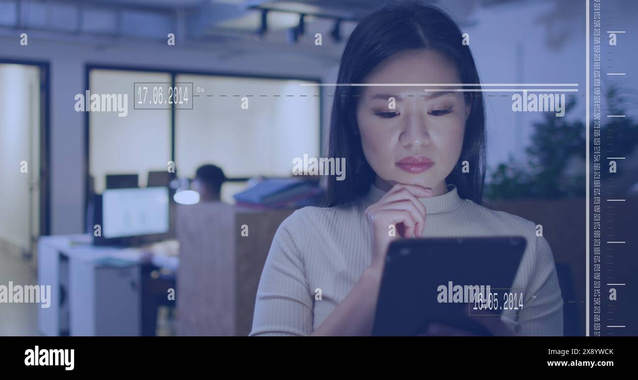 Image of interface with data processing against asian woman using digital tablet at office Stock Photo