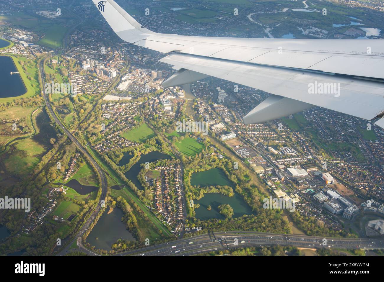 Egyptair Airbus A320 Neo wing on aircraft climbing out of London Heathrow Airport as it passes over Staines upon Thames and the M25 London Orbital mot Stock Photo
