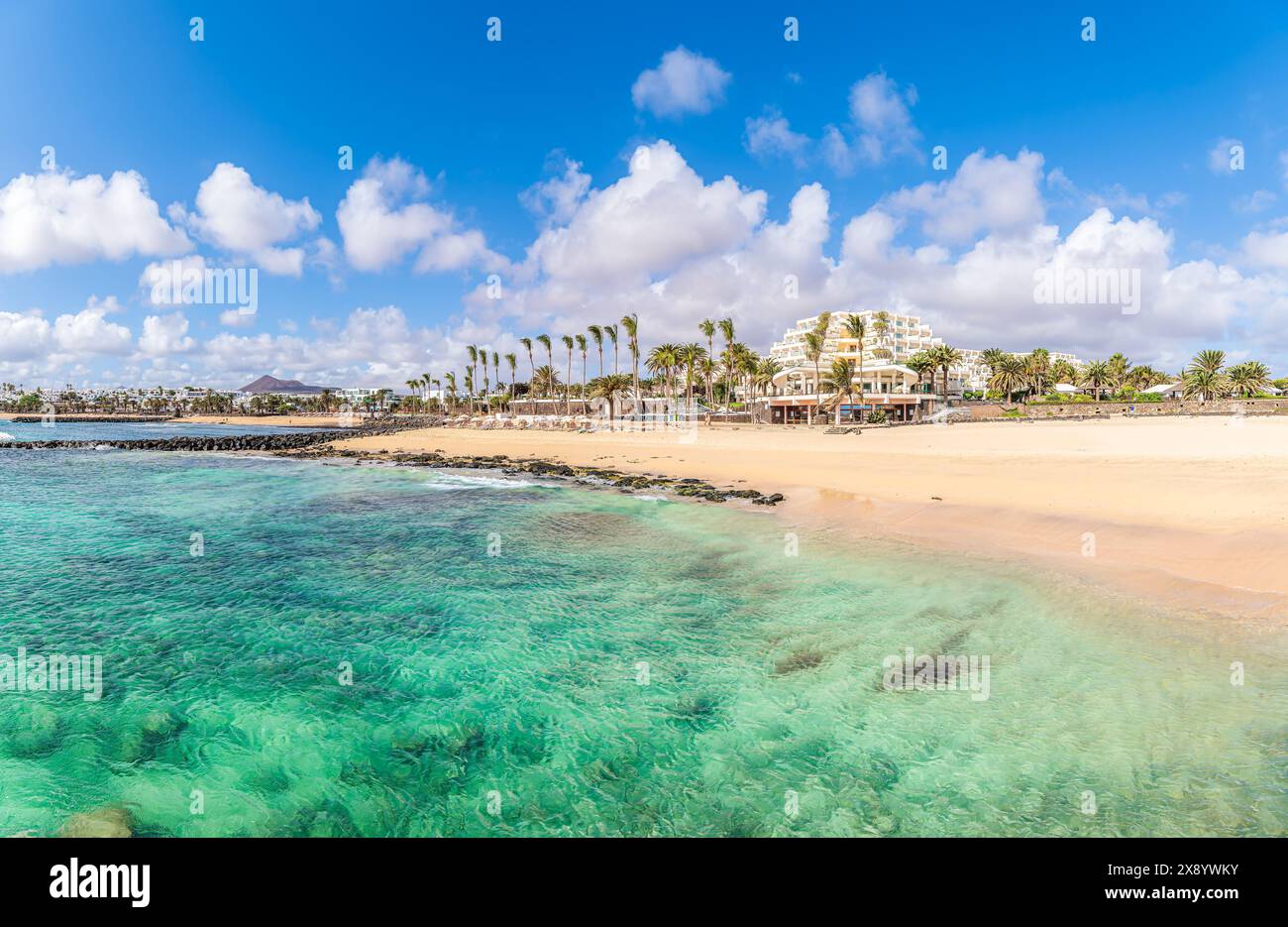 Playa de las Cucharas, Costa Teguise, Lanzarote: A perfect family beach with golden sand, turquoise waters, and a variety of water sports. Stock Photo
