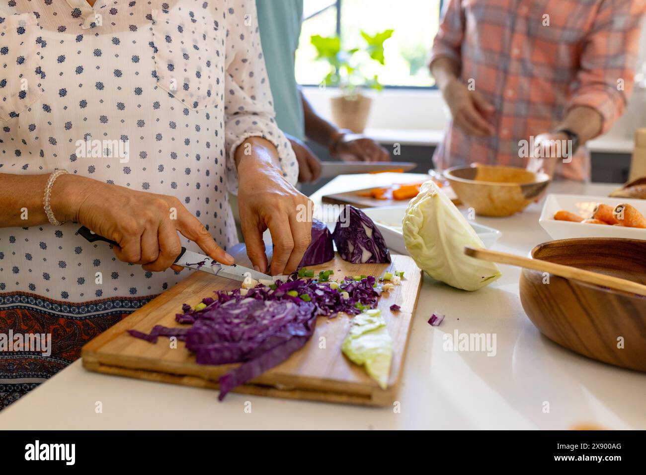 Diverse senior friends cooking together at home Stock Photo