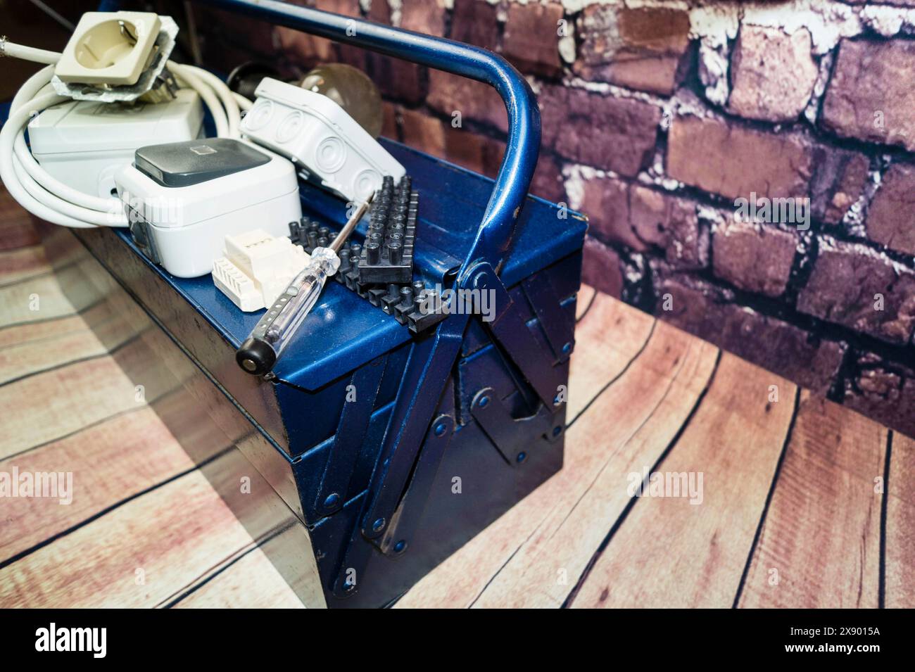 toolbox with switch, socket, light bulb and power cable, symbol image for electricians Stock Photo