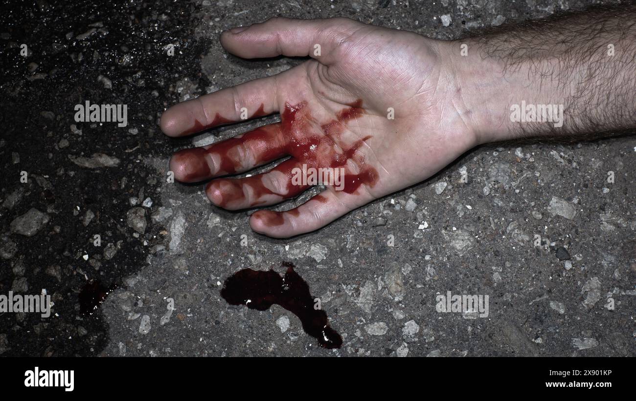Forensic Photo Taken at Crime scene: Bloody Hand of the Victim's Corpse.Realistic Picture Taken By Police of Blood Splatter Due to a Stabbing Wound. Crime Evidence Picture Stock Photo