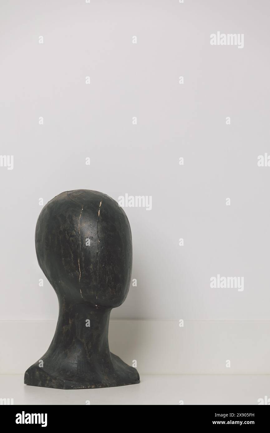 Aged Black Wooden Mannequin Head with Distinctive Cracks on Clean White Background – Minimalist Antique Decor Piece Stock Photo