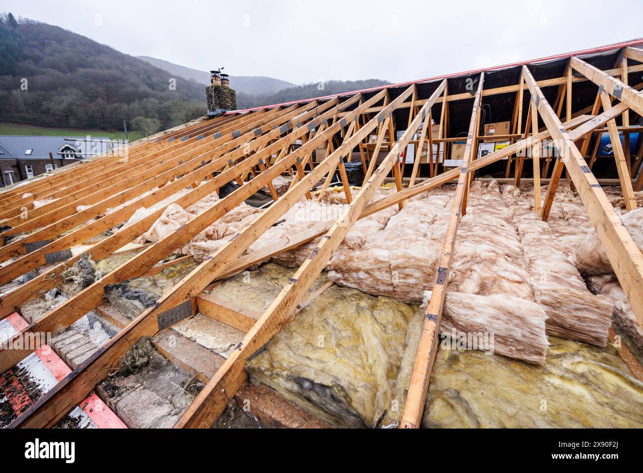 Exposed lagging in loft during reroofing project on house, Llanfoist, Wales, UK Stock Photo