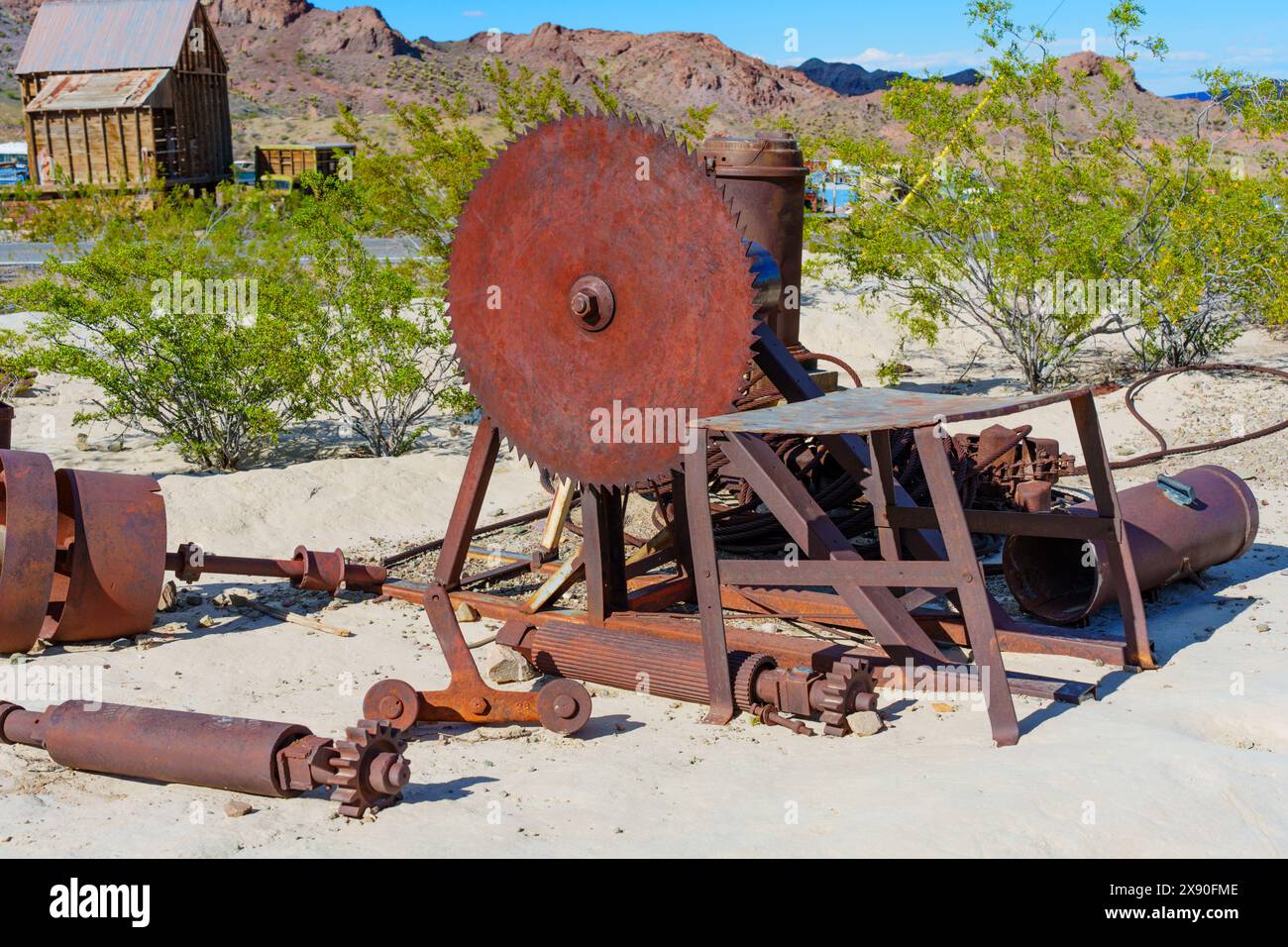 Nelson, Nevada - April 15, 2024: Abandoned, rusty circular saw and remnants of old machinery are scattered on sandy ground outdoors in Nelson Ghost To Stock Photo