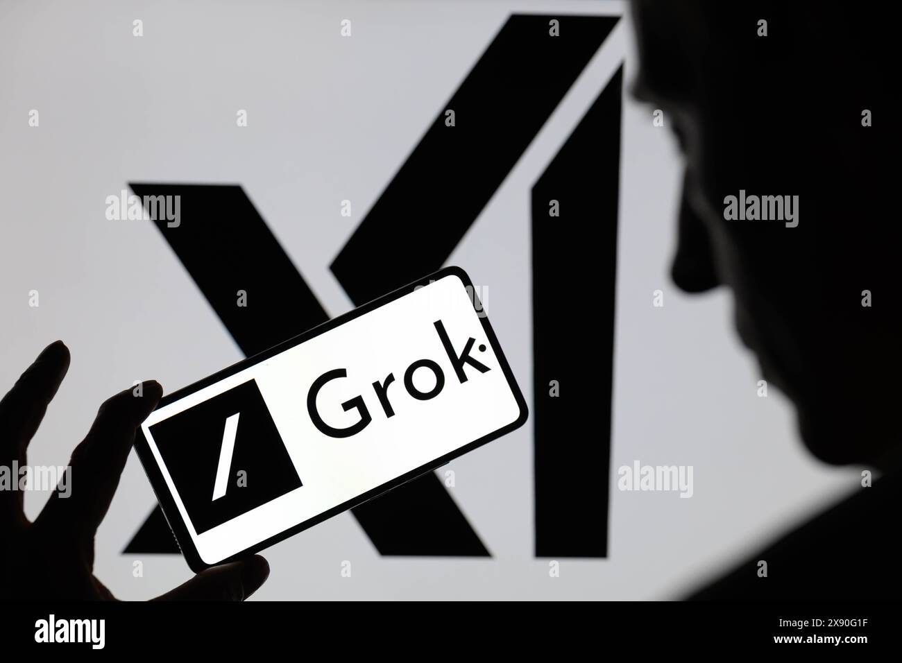 Grok logo is being displayed on a smartphone with X AI icon visible on