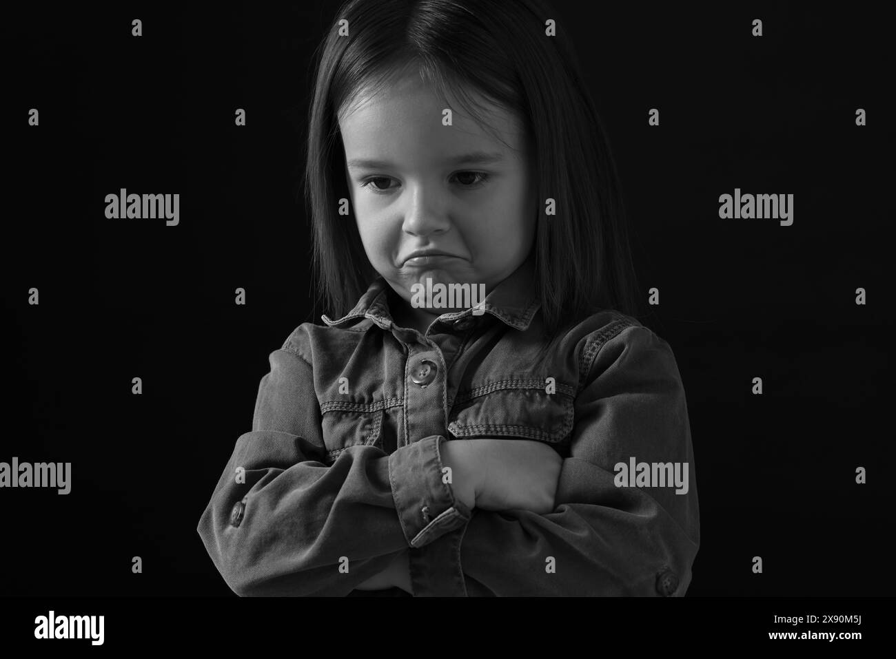 Portrait of sad girl on dark background, closeup. Black and white effect Stock Photo