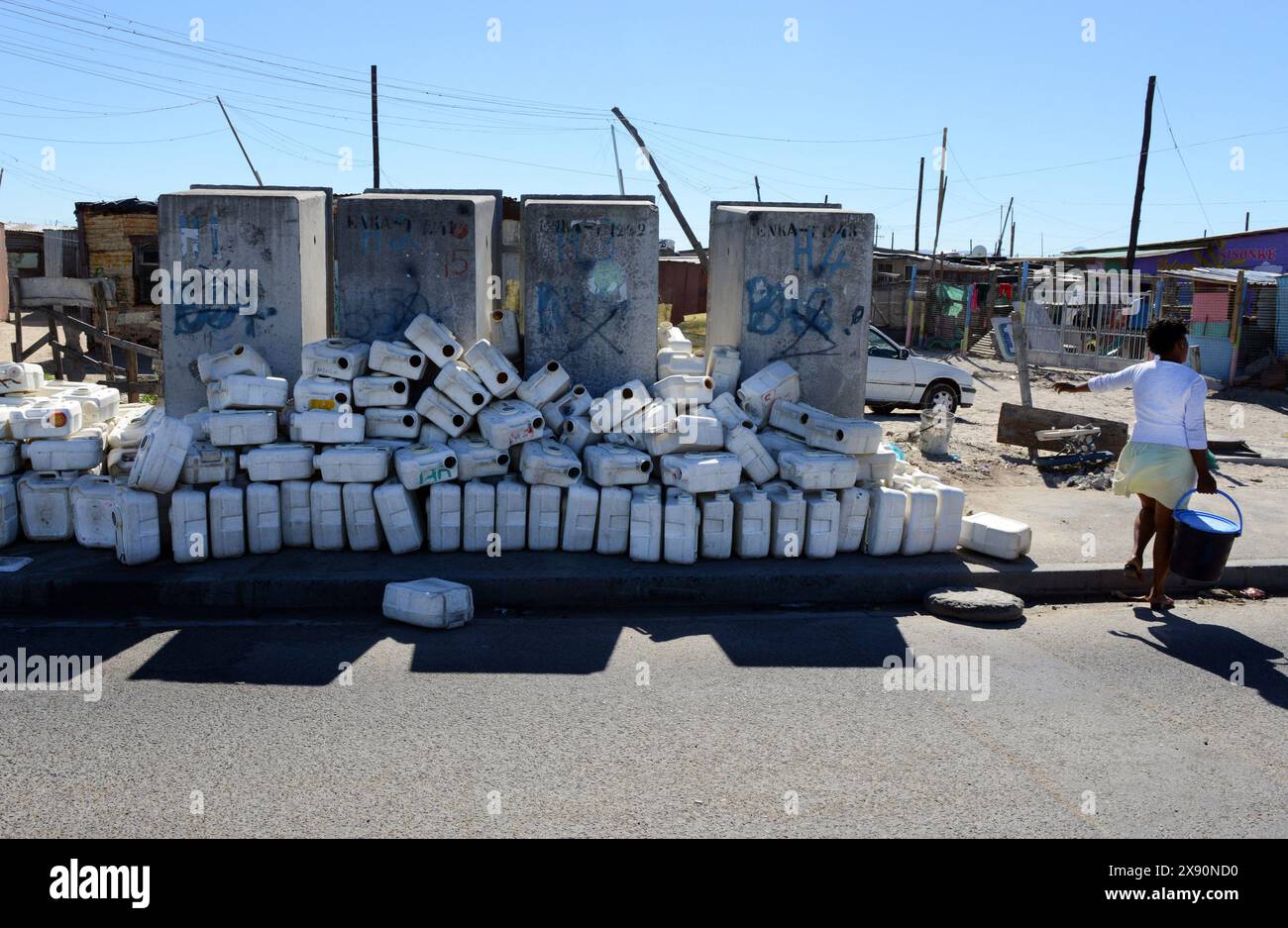 Communal toilets in Khayelitsha. The grey structures are plumbed/flushing toilets linked to the sewage system. The white containers are from 'porta-potties' used by many householders. They are supposed to be exchanged and cleaned by the municipality on a regular basis. Stock Photo