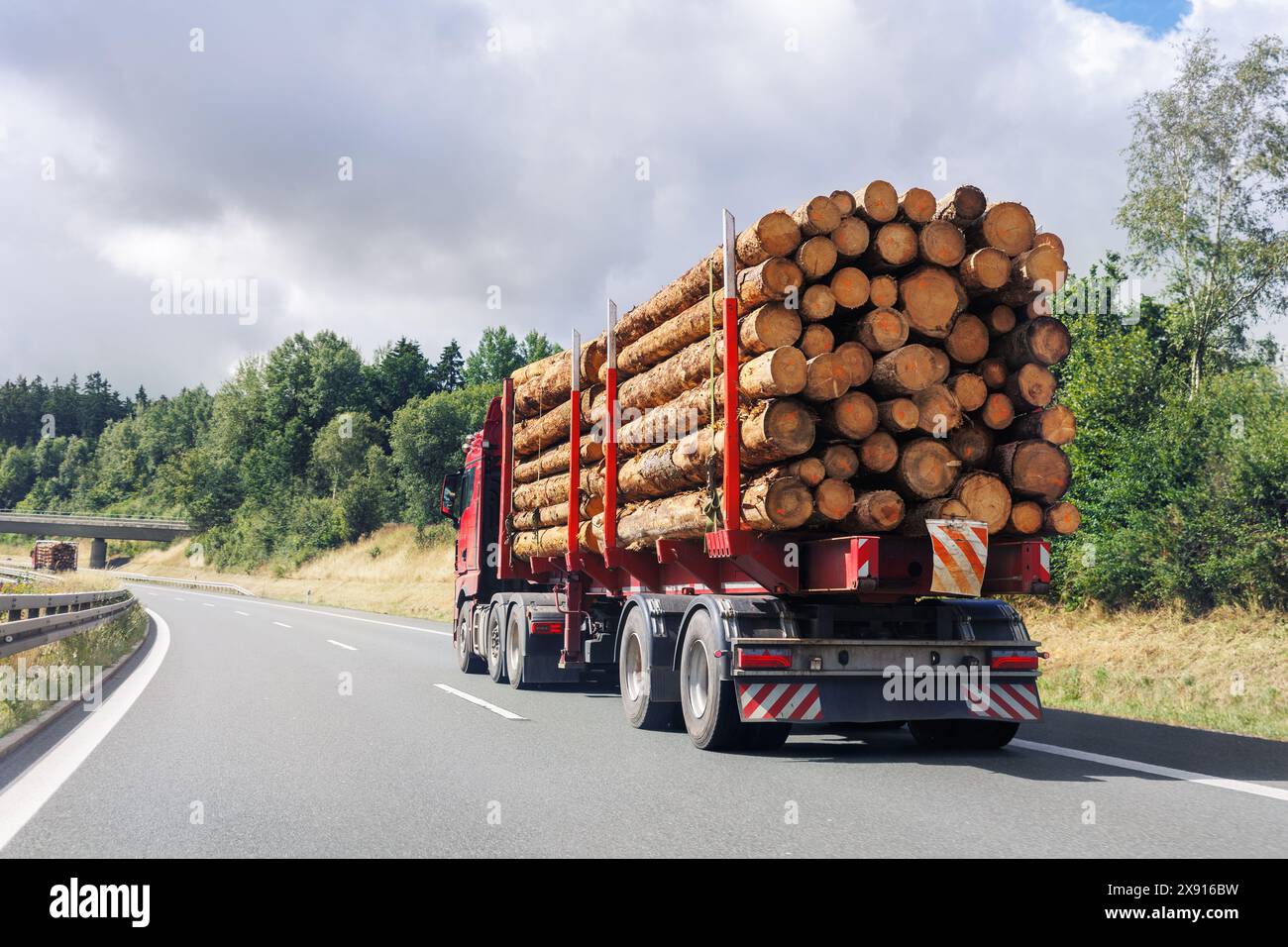 Back view many long heavy industrial wood carrier cargo vessel truck ...