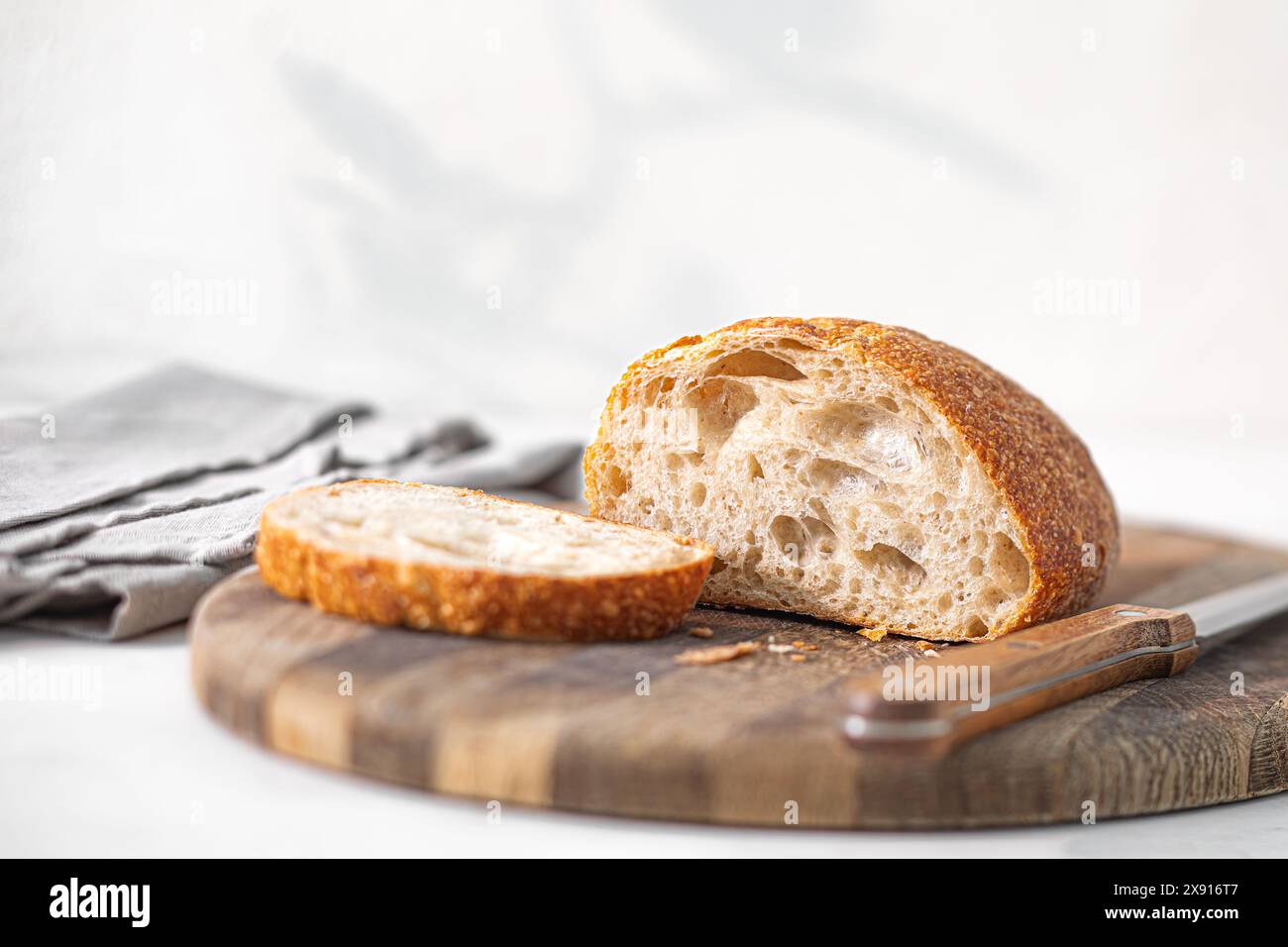 Freshly Baked Artisan Bread Ciabatta on Wooden Cutting Board in a Bright Kitchen Morning Stock Photo