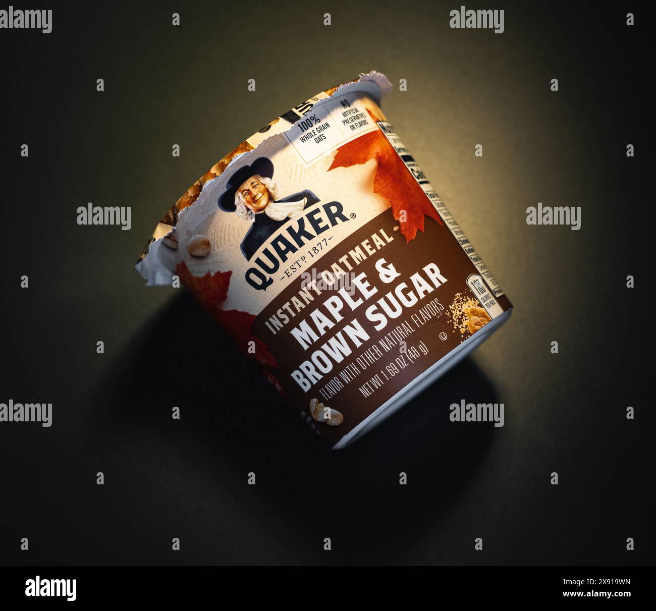 Quaker Maple and Brown Sugar instant oatmeal cup on black matte ...