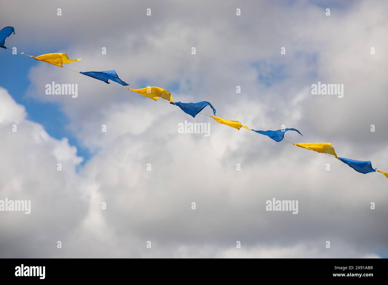 Yellow and blue triangular festival flags on sky background with white ...