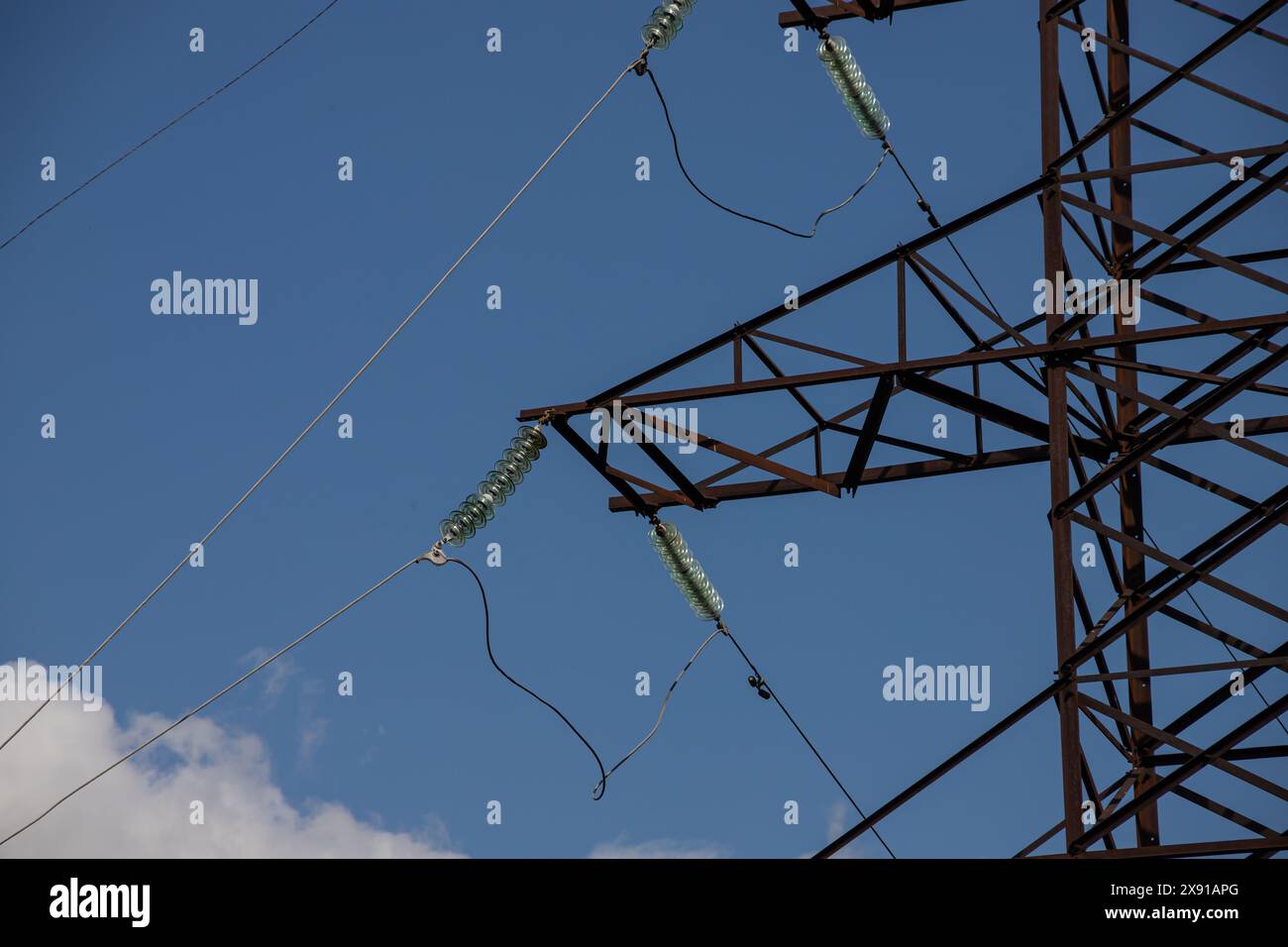 Power lines on background of blue sky close-up. Electric hub on pole. Electricity equipment with copy space. Wires of high voltage in sky. Stock Photo