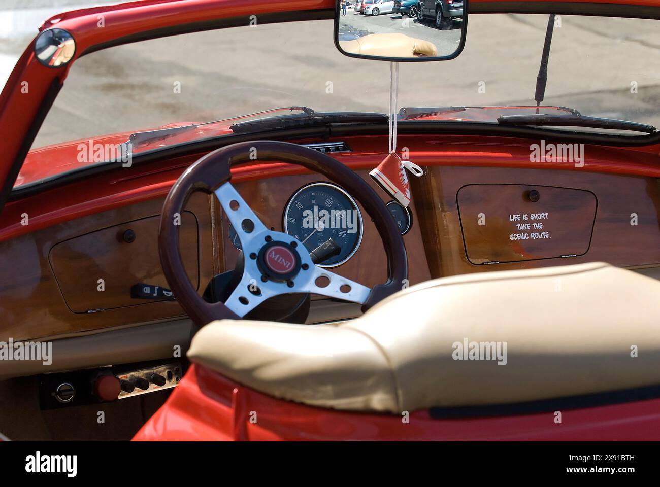 Microcar Convertible Red vintage convertible microcar driving through city street traffic ...