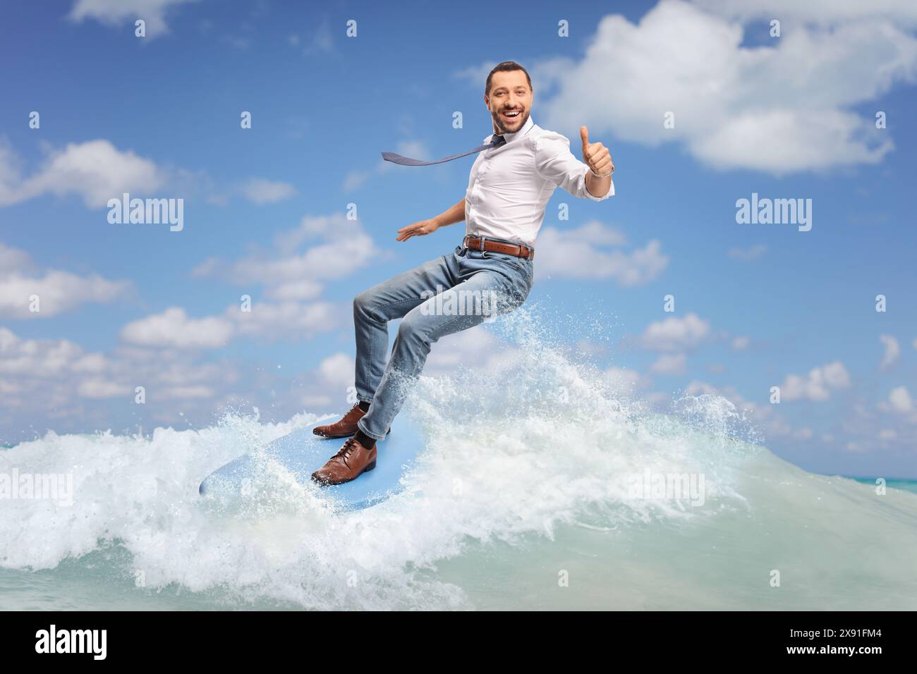 Happy businessman riding a surfboard on a sea wave and gesturing thumbs ...