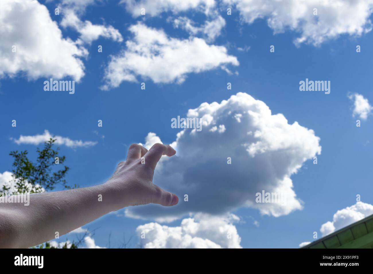 Child's hand arranges clouds in sky. concept of cloud computing Stock Photo
