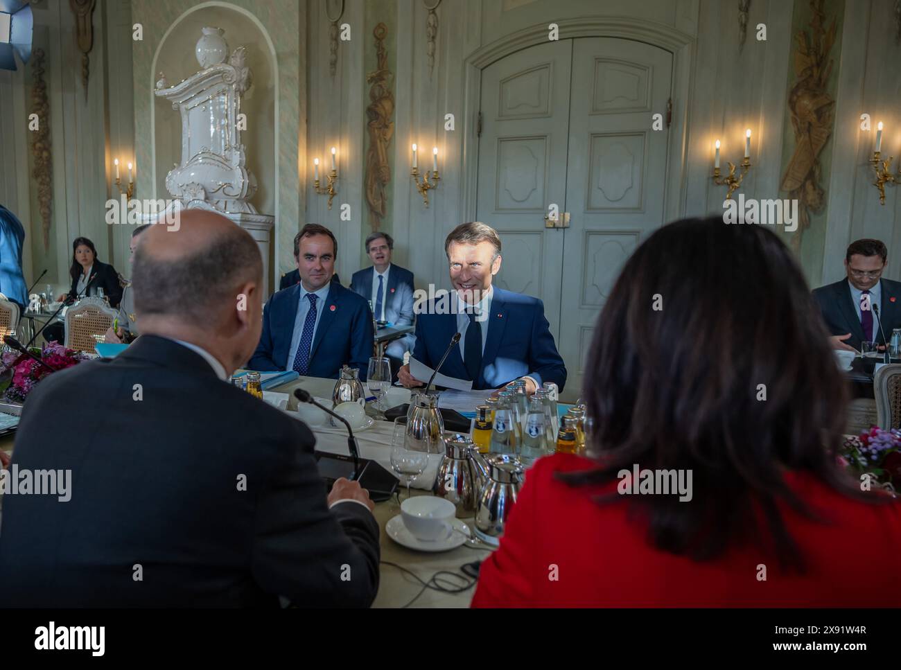 Gransee, Germany. 28th May, 2024. Federal Chancellor Olaf Scholz (SPD), sits next to Annalena Baerbock (Bündnis90/Die Grünen), Foreign Minister, opposite Emmanuel Macron, President of France, at the working session at the Franco-German Council of Ministers in front of Schloss Meseberg, the Federal Government's guest house. Credit: Michael Kappeler/dpa-Pool/dpa/Alamy Live News Stock Photo