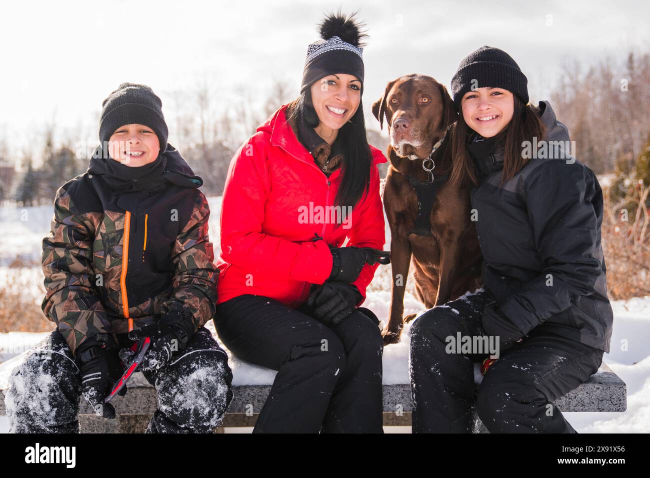 Portrait of family with labrador dog in winter season Stock Photo