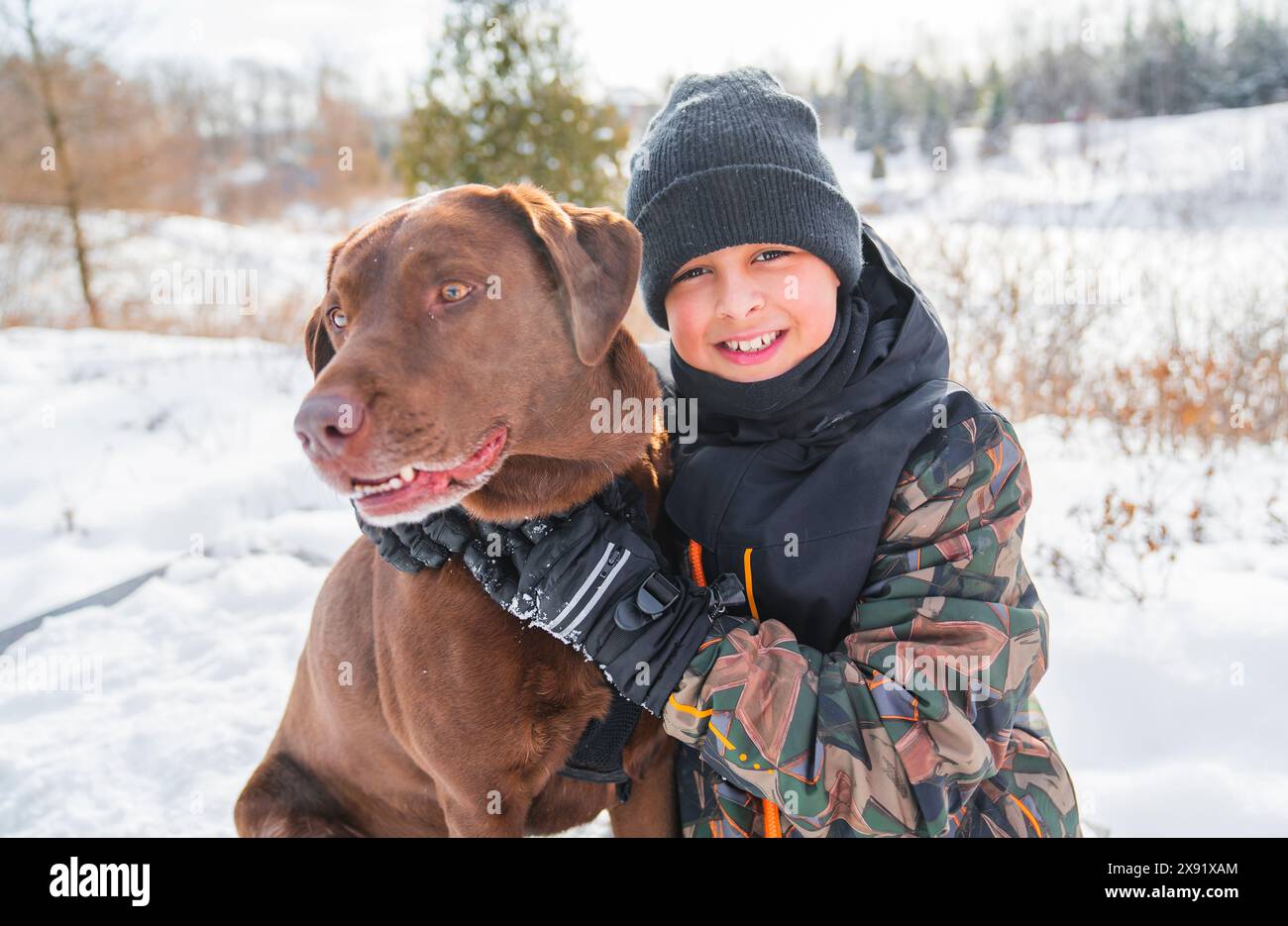 Portrait of little boy with labrador dog in winter season Stock Photo