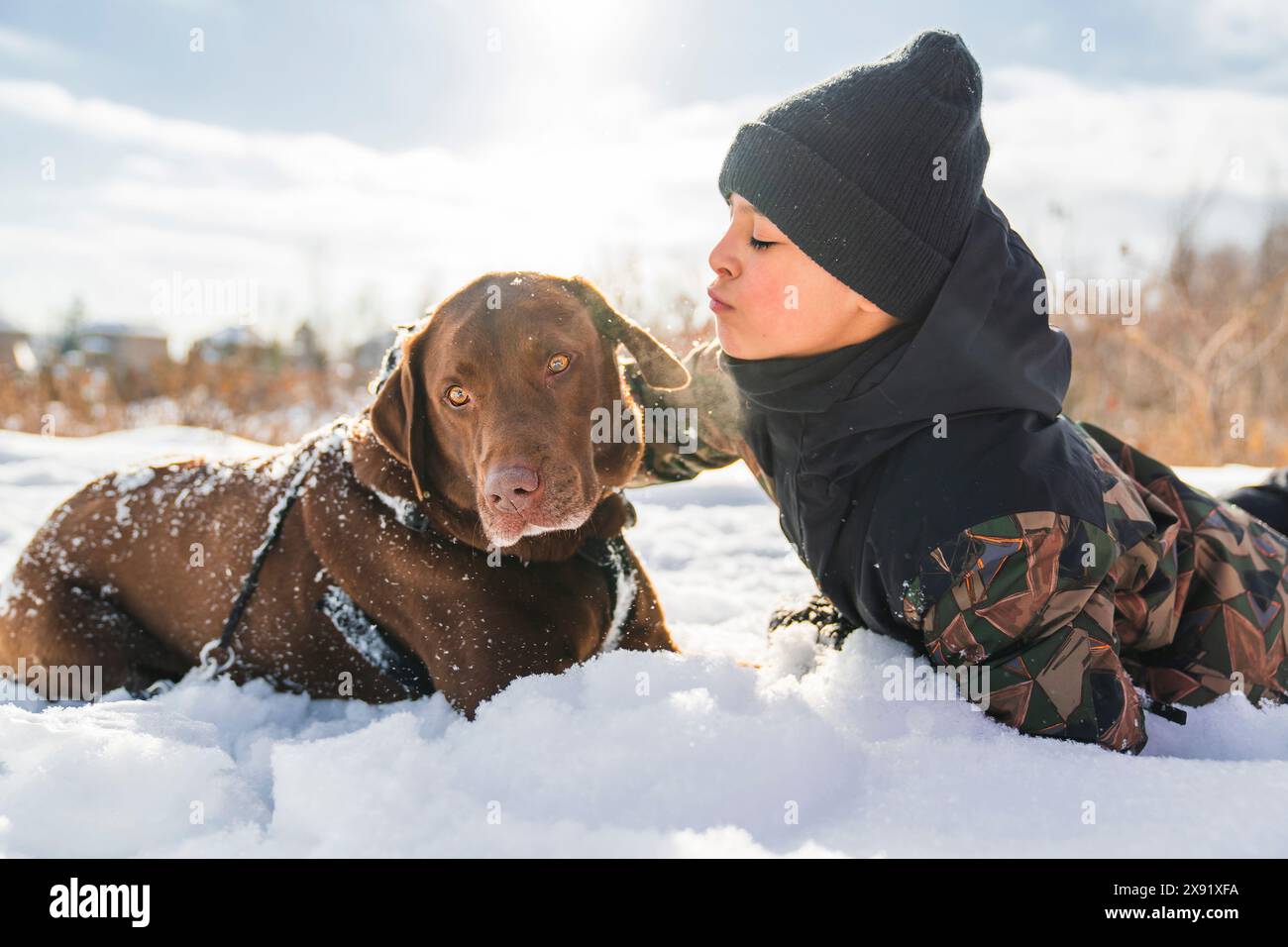 Portrait of little boy with labrador dog in winter season Stock Photo