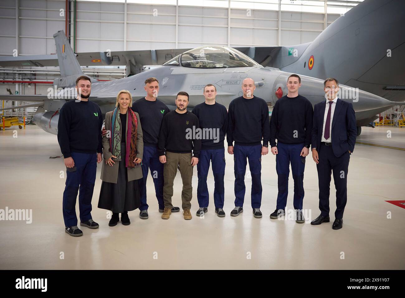 Steenokkerzeel, Belgium. 28th May, 2024. Ukrainian President Volodymyr Zelenskyy, center, and Belgian Defence minister Ludivine Dedonder, 2nd left, pose with Ukraine pilots training on the F-16 fighter aircraft at Melsbroek Air Base, May 28, 2024 in Steenokkerzeel, Belgium. Belgium pledged 30 of the advanced multirole fighters in a new bilateral security agreement. Credit: Pool Photo/Ukrainian Presidential Press Office/Alamy Live News Stock Photo
