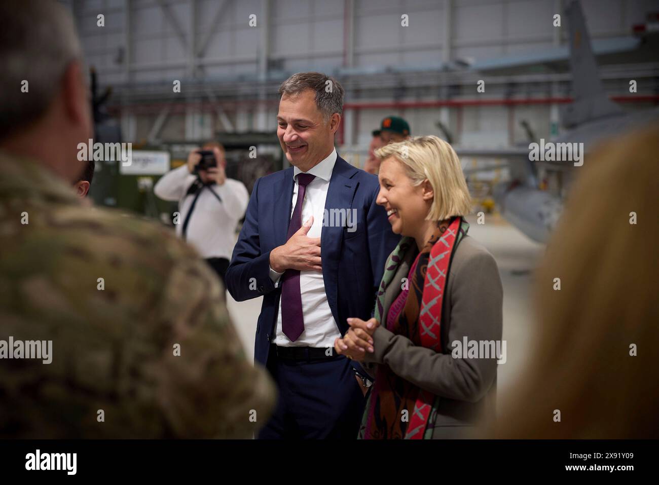 Steenokkerzeel, Belgium. 28th May, 2024. Belgian Prime Minister Alexander De Croo, left, and Defence minister Ludivine Dedonder, right, smile as Ukrainian President Volodymyr Zelenskyy, chats with Ukrainian pilots training on the F-16 fighter aircraft at Melsbroek Air Base, May 28, 2024 in Steenokkerzeel, Belgium. Belgium pledged 30 of the advanced multirole fighters in a new bilateral security agreement. Credit: Pool Photo/Ukrainian Presidential Press Office/Alamy Live News Stock Photo