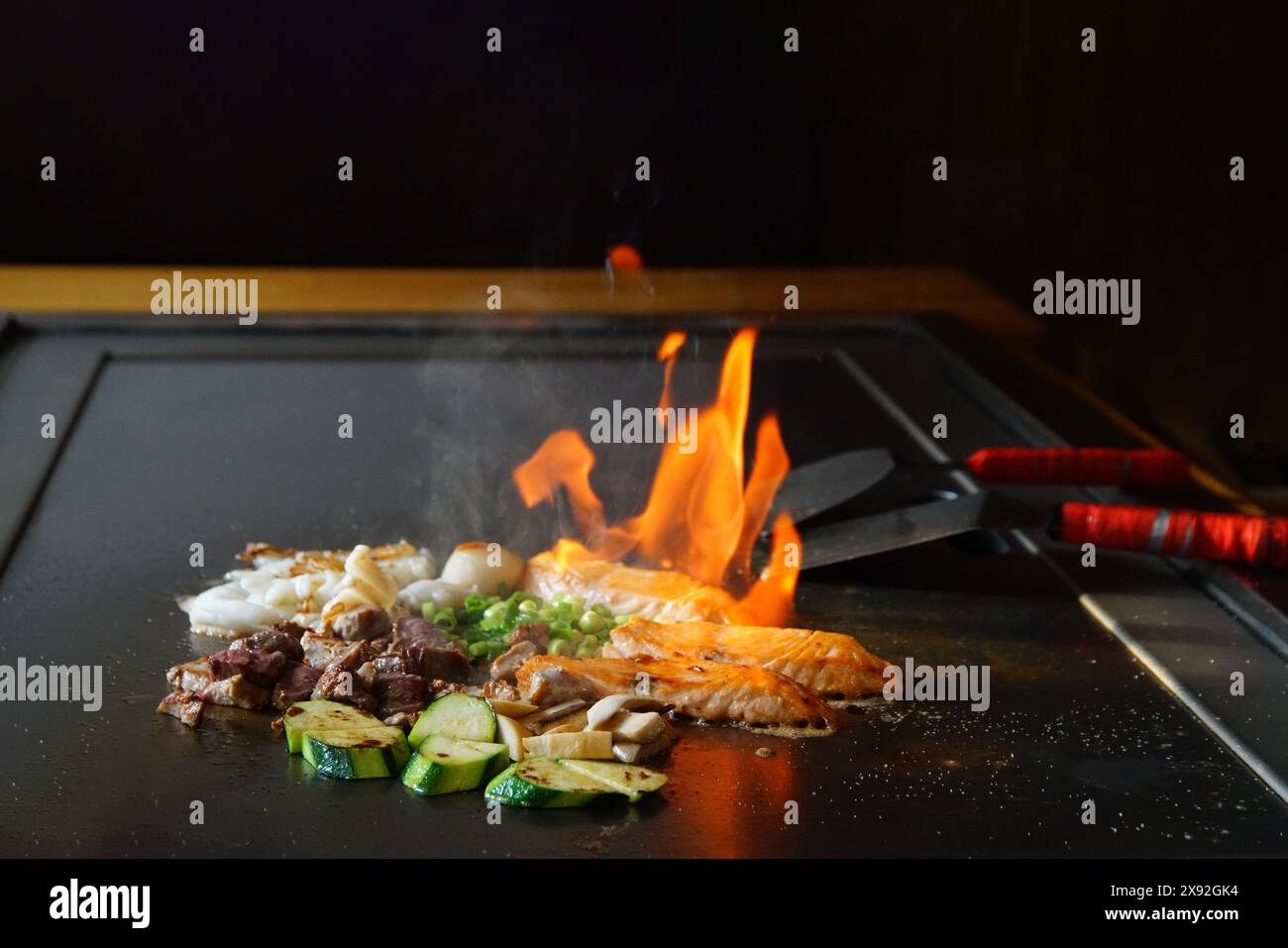 chef's hands with spatula over teppanyaki. cooking vegetables meat and