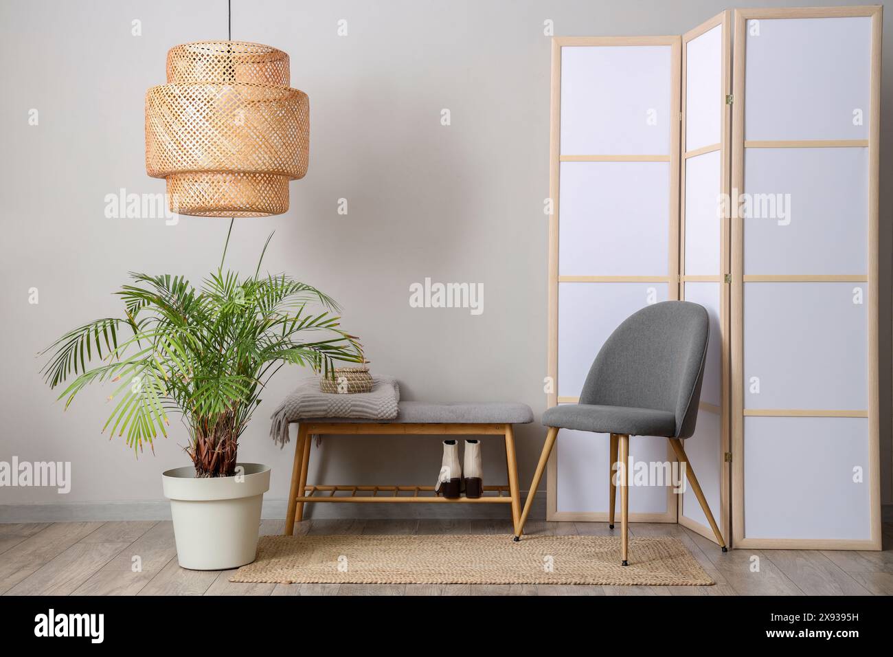 Interior of room with folding screen, bench and chair near white wall ...