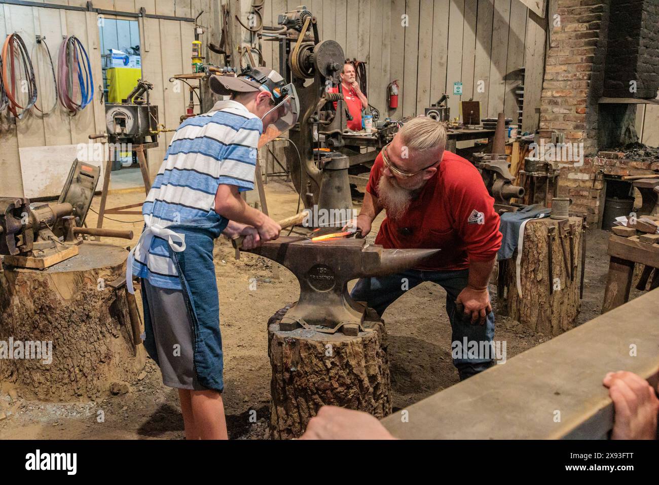 Park guest gets hands on experience at the Valley Forge Blacksmith demonstration at the Dollywood amusement park in Pigeon Forge, TN Stock Photo