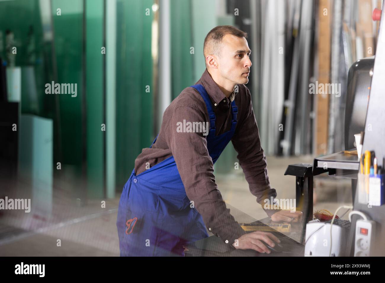 Glass processing factory worker operating CNC machine Stock Photo - Alamy