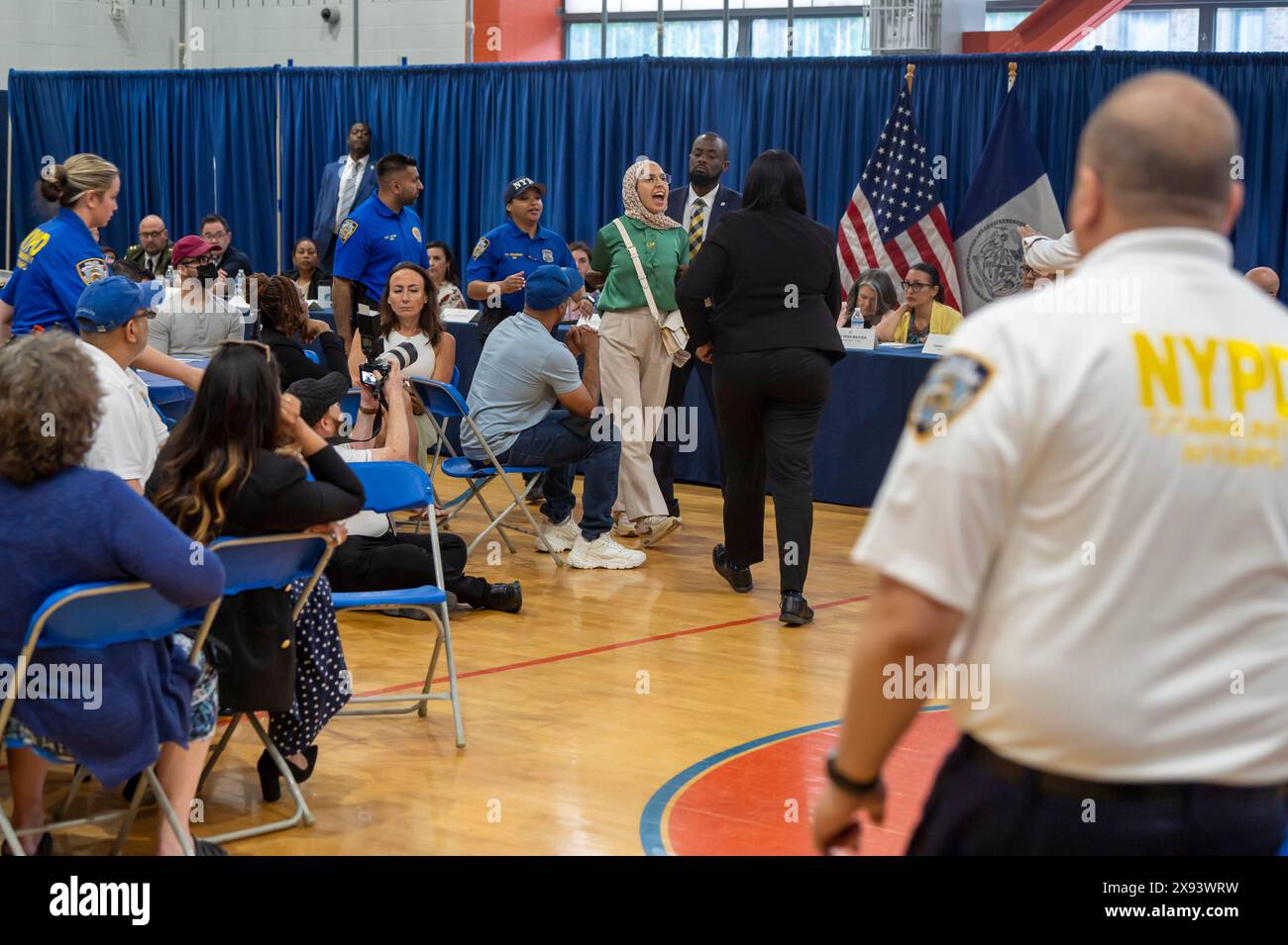 New York, United States. 28th May, 2024. NEW YORK, NEW YORK - MAY 28: A demonstrator is escorted out by NYPD Police Officers after he interrupted a speech by New York City Mayor Eric Adams at Frank Sinatra School of the Arts High School, Astoria on May 28, 2024 in the Queens Borough of New York City. Credit: Ron Adar/Alamy Live News Stock Photo