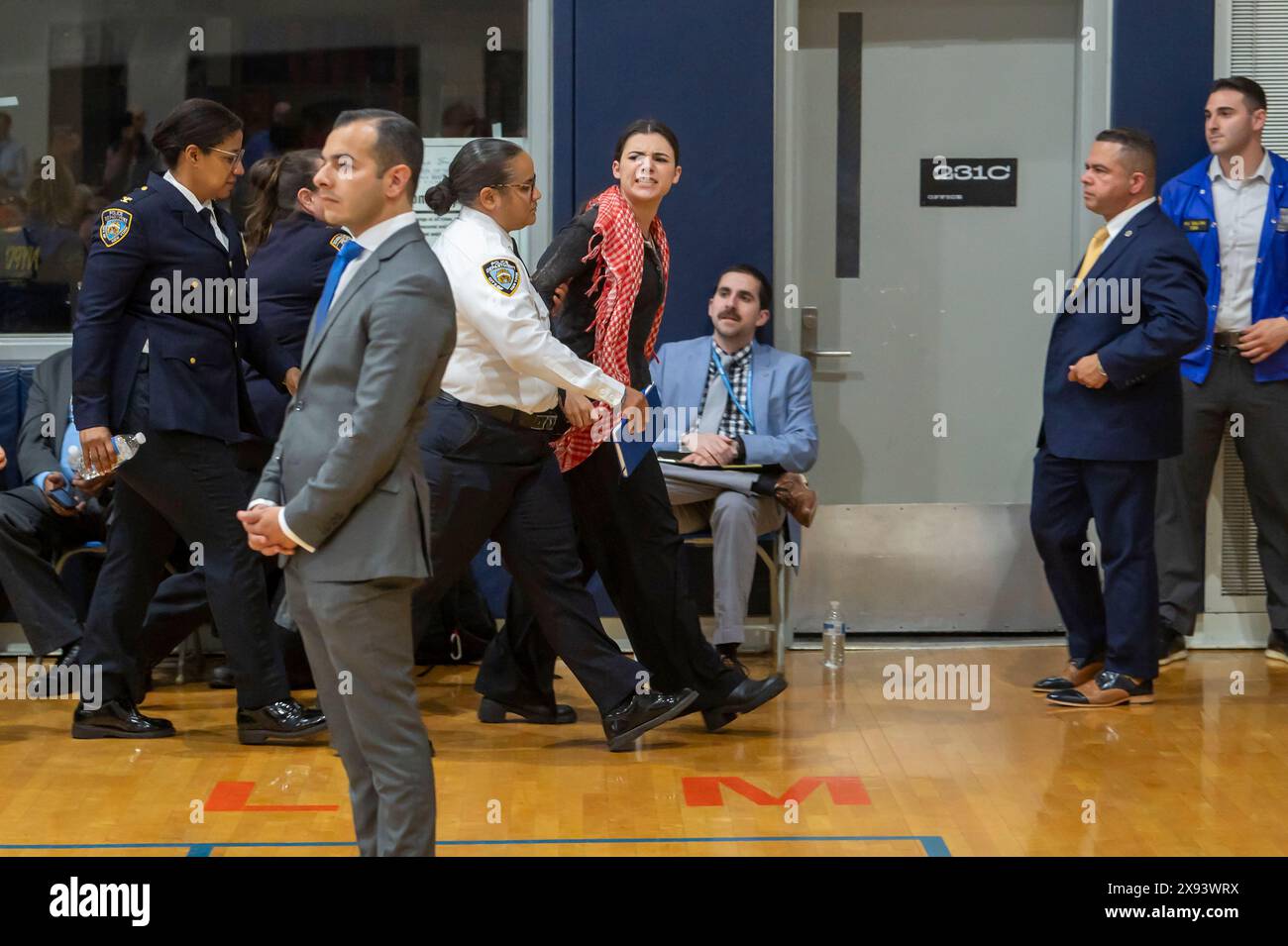 New York, United States. 28th May, 2024. NEW YORK, NEW YORK - MAY 28: A demonstrator is escorted out by NYPD Police Officers after he interrupted a speech by New York City Mayor Eric Adams at Frank Sinatra School of the Arts High School, Astoria on May 28, 2024 in the Queens Borough of New York City. Credit: Ron Adar/Alamy Live News Stock Photo