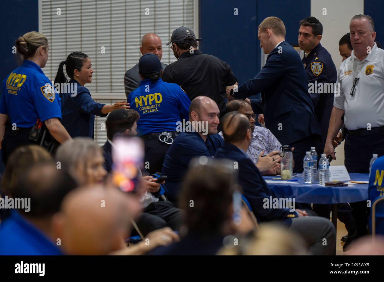 New York, United States. 28th May, 2024. NEW YORK, NEW YORK - MAY 28: A demonstrator is escorted out by NYPD Police Officers after he interrupted a speech by New York City Mayor Eric Adams at Frank Sinatra School of the Arts High School, Astoria on May 28, 2024 in the Queens Borough of New York City. Credit: Ron Adar/Alamy Live News Stock Photo