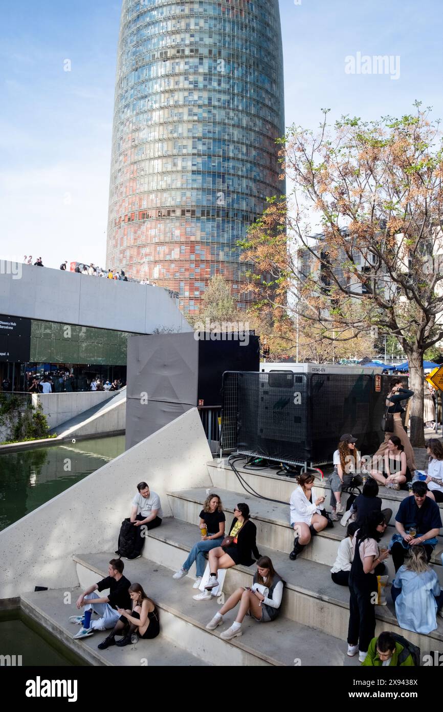 Attendees sit by the moat water feature to chill out and mingle between talks at OFFF Barcelona at Disseny Hub Museum of Design in Barcelona, Spain in April 2024.  Picture: Rob Watkins.  INFO: The popular annual conference launched in 2001 and is the world's  largest showcase of contemporary visual creativity and design. It attracts designers, artists, filmmakers and photographers from around the world and serves as a global platform for creative exchange and collaboration. Stock Photo