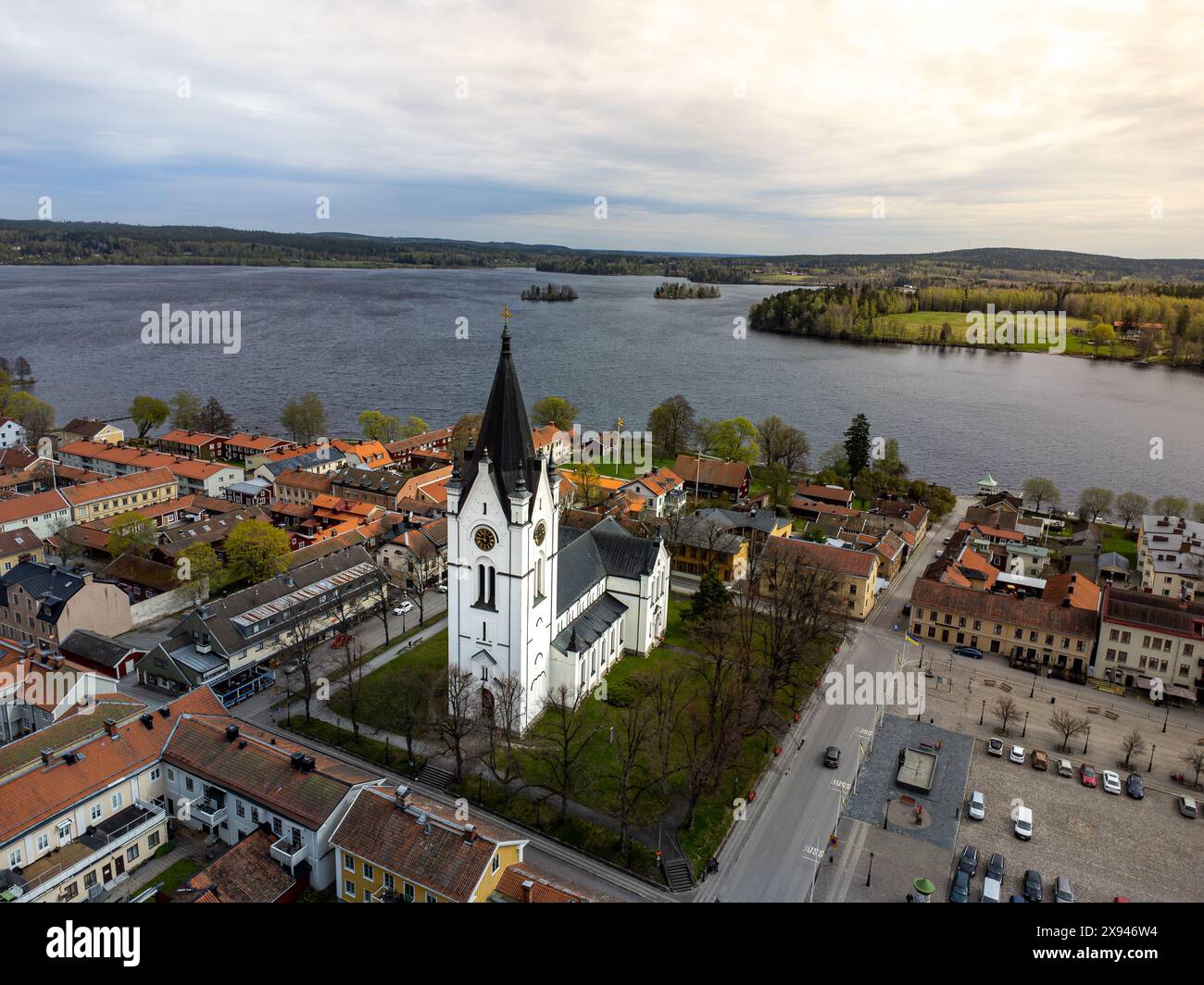 Aerial view of a picturesque town with a central church and a lake, showcasing the scenic beauty and heritage. Stock Photo