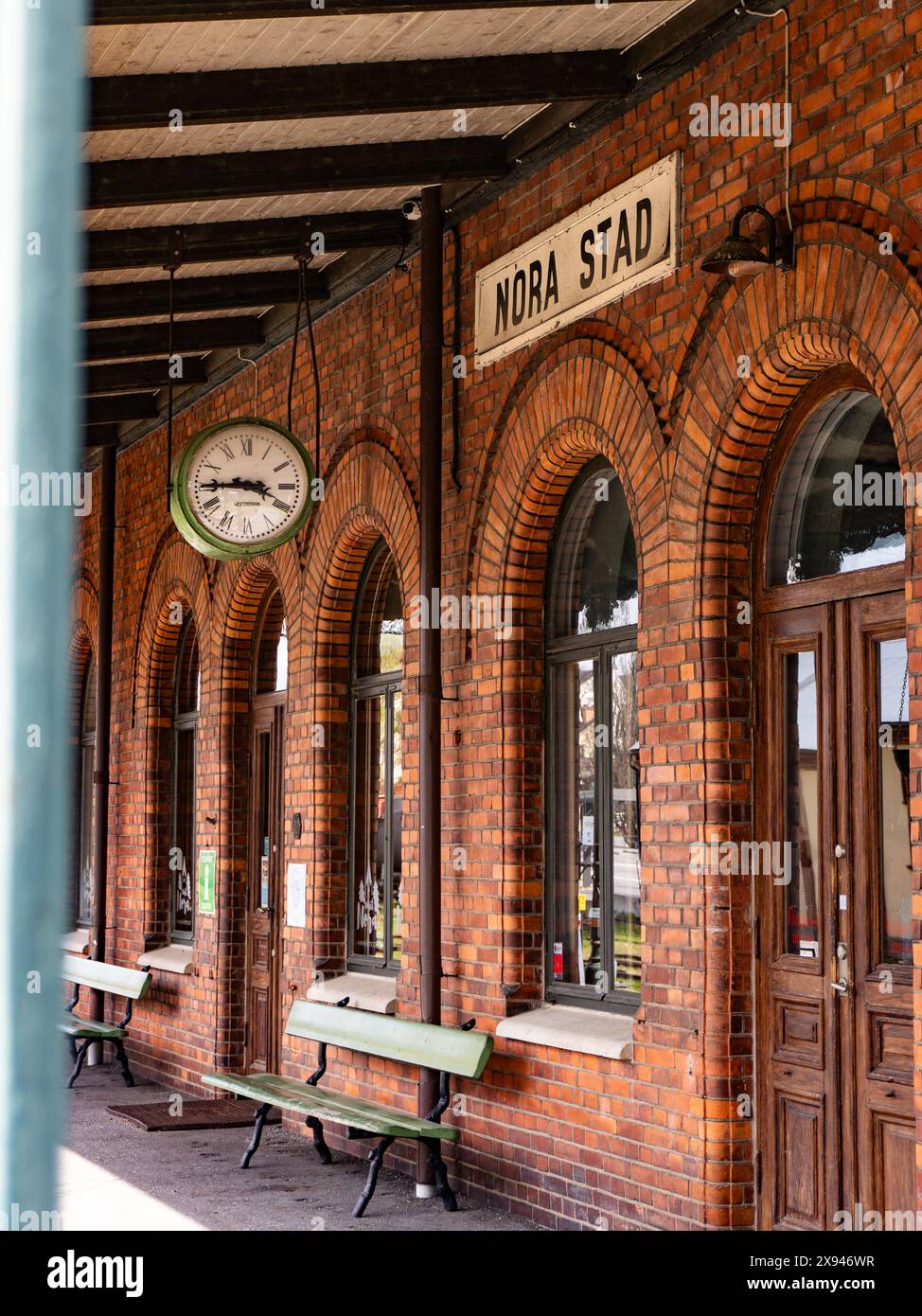 Old train station building with a clock, highlighting historical architecture and rural charm. Stock Photo