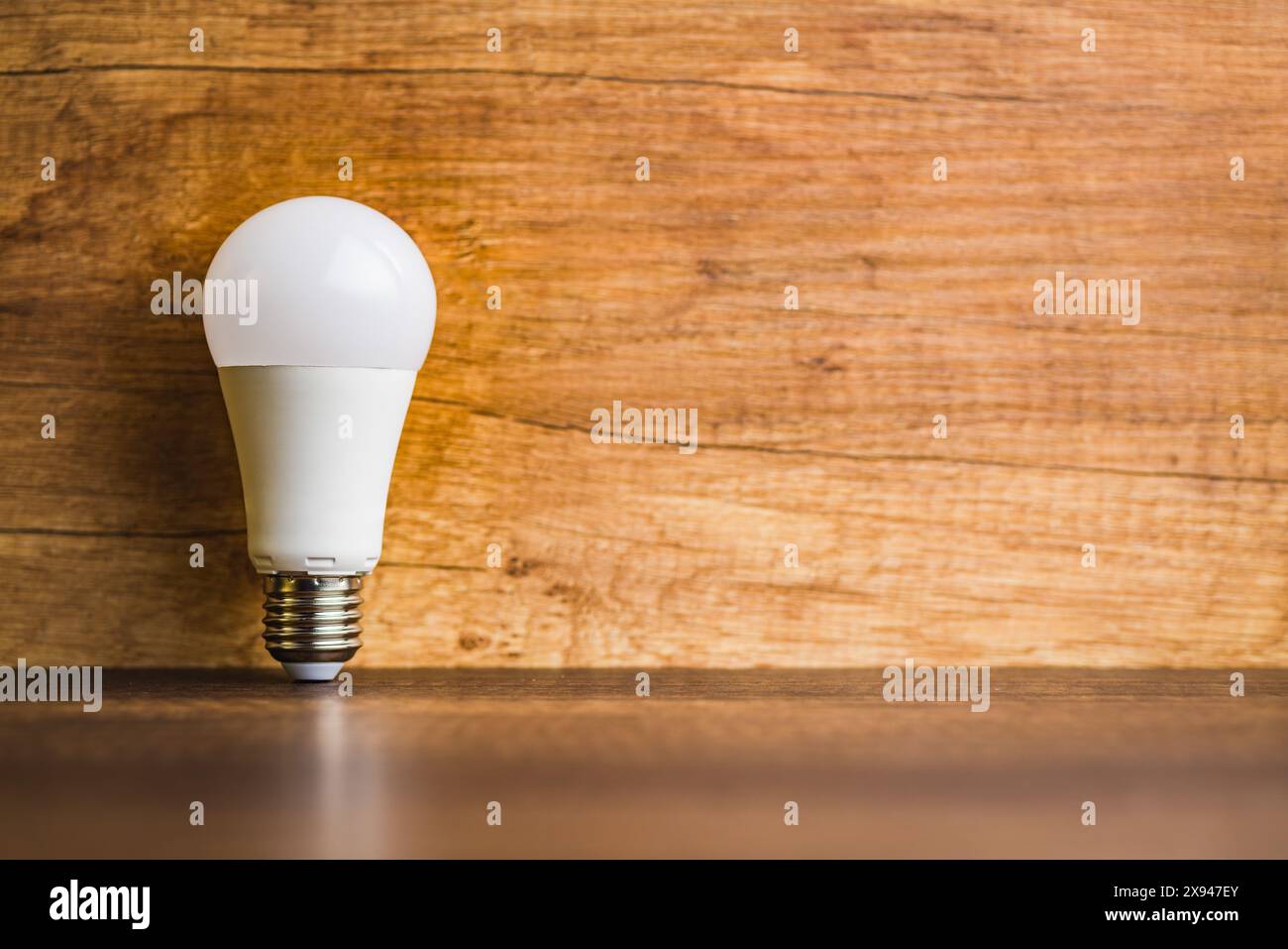 Energy saving light bulb on a wooden table. Led Lightbulb. Stock Photo