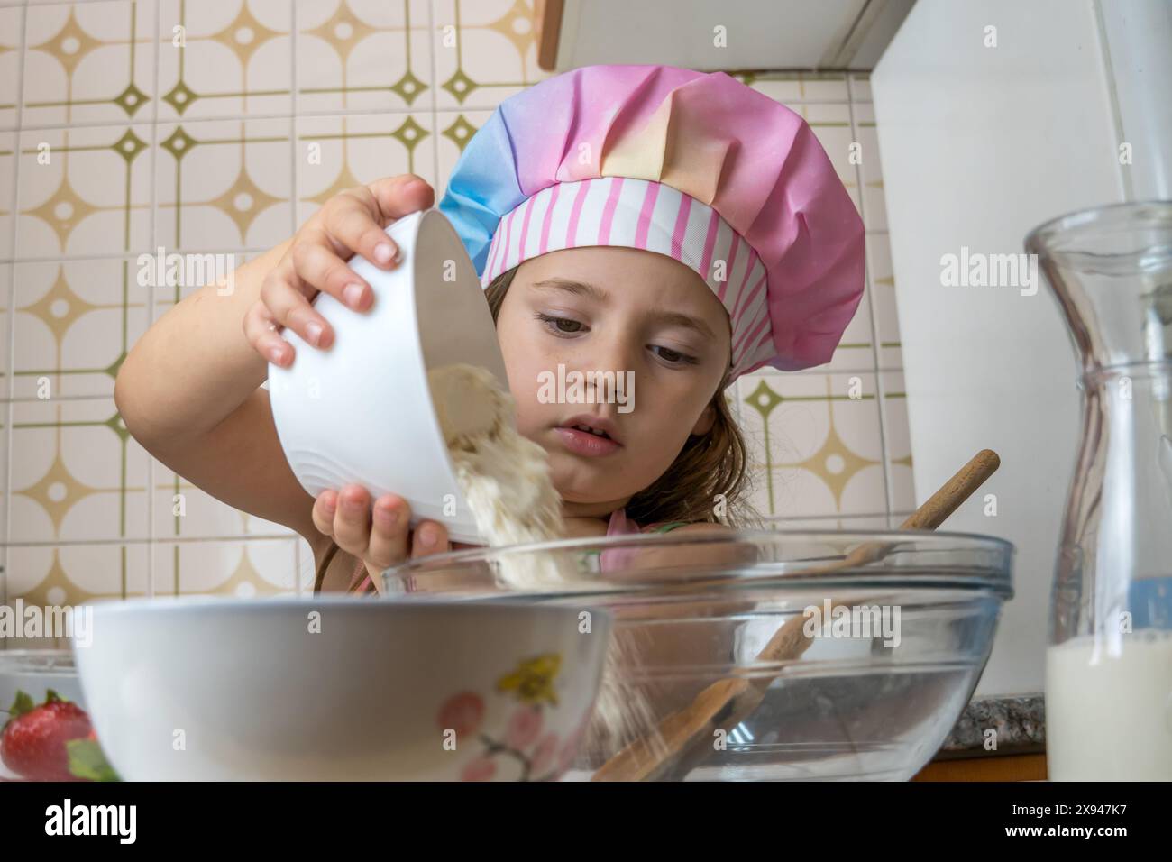 a girl dressed as a cook enjoying an afternoon of cooking with her ...