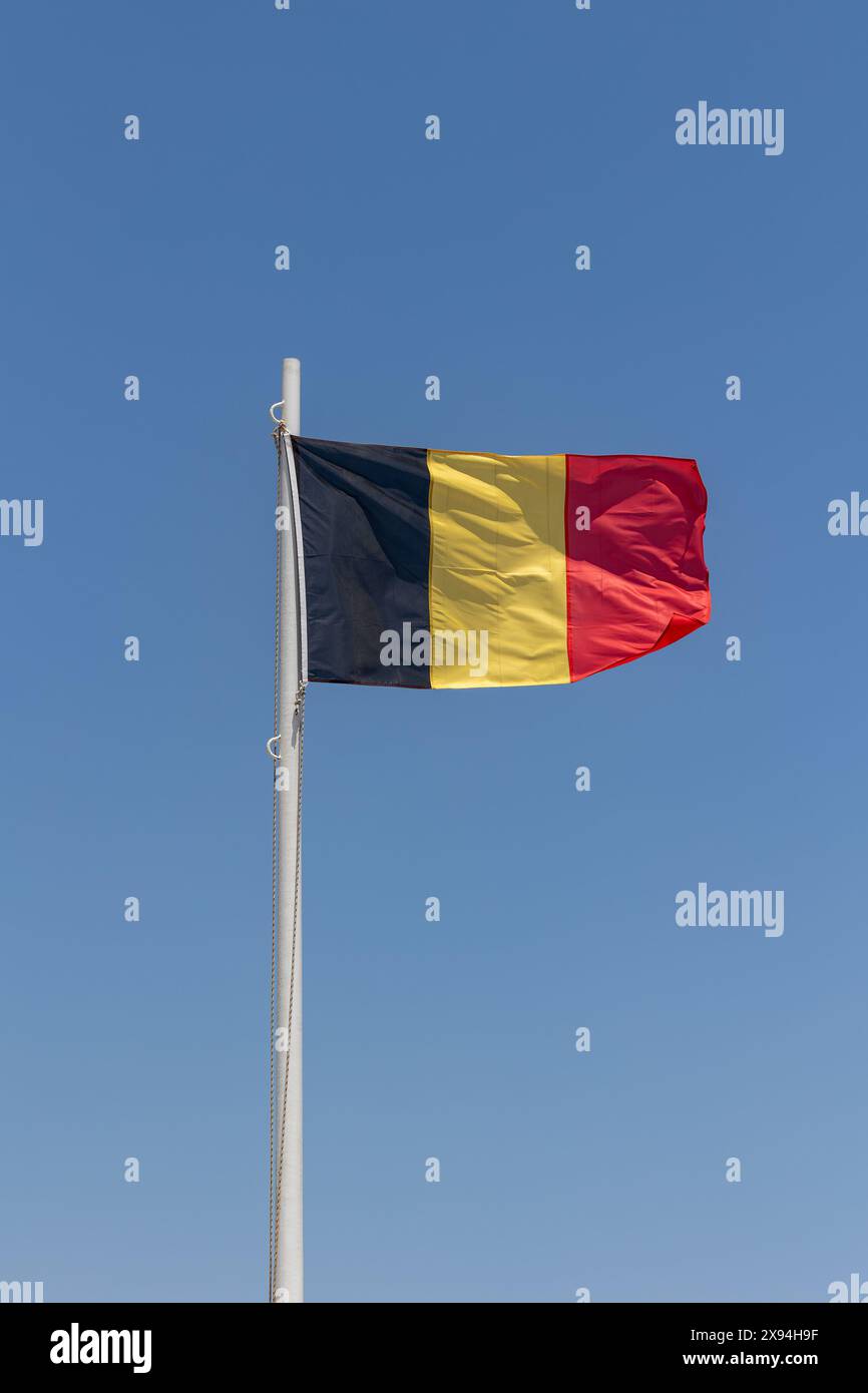 German flag attached to pole waving in the wind cloudless blue sky background Stock Photo
