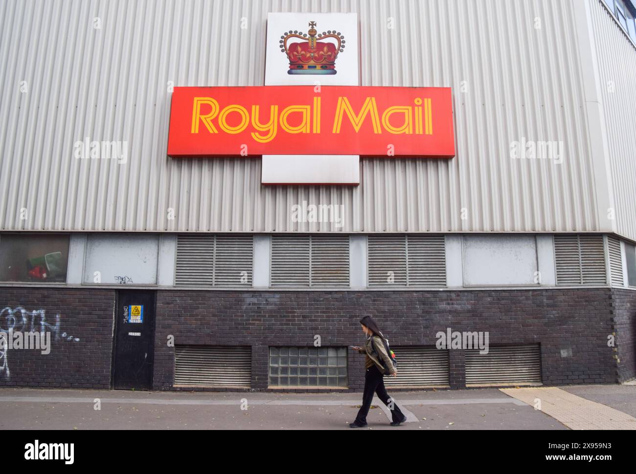 London, UK. 29th May 2024. A woman walks past the Royal Mail NW1 Delivery Office in Camden. International Distributions Services (IDS), the parent company of Royal Mail, has agreed to a 3.57 billion pound takeover by Czech billionaire Daniel Kretinsky. Credit: Vuk Valcic/Alamy Live News Stock Photo